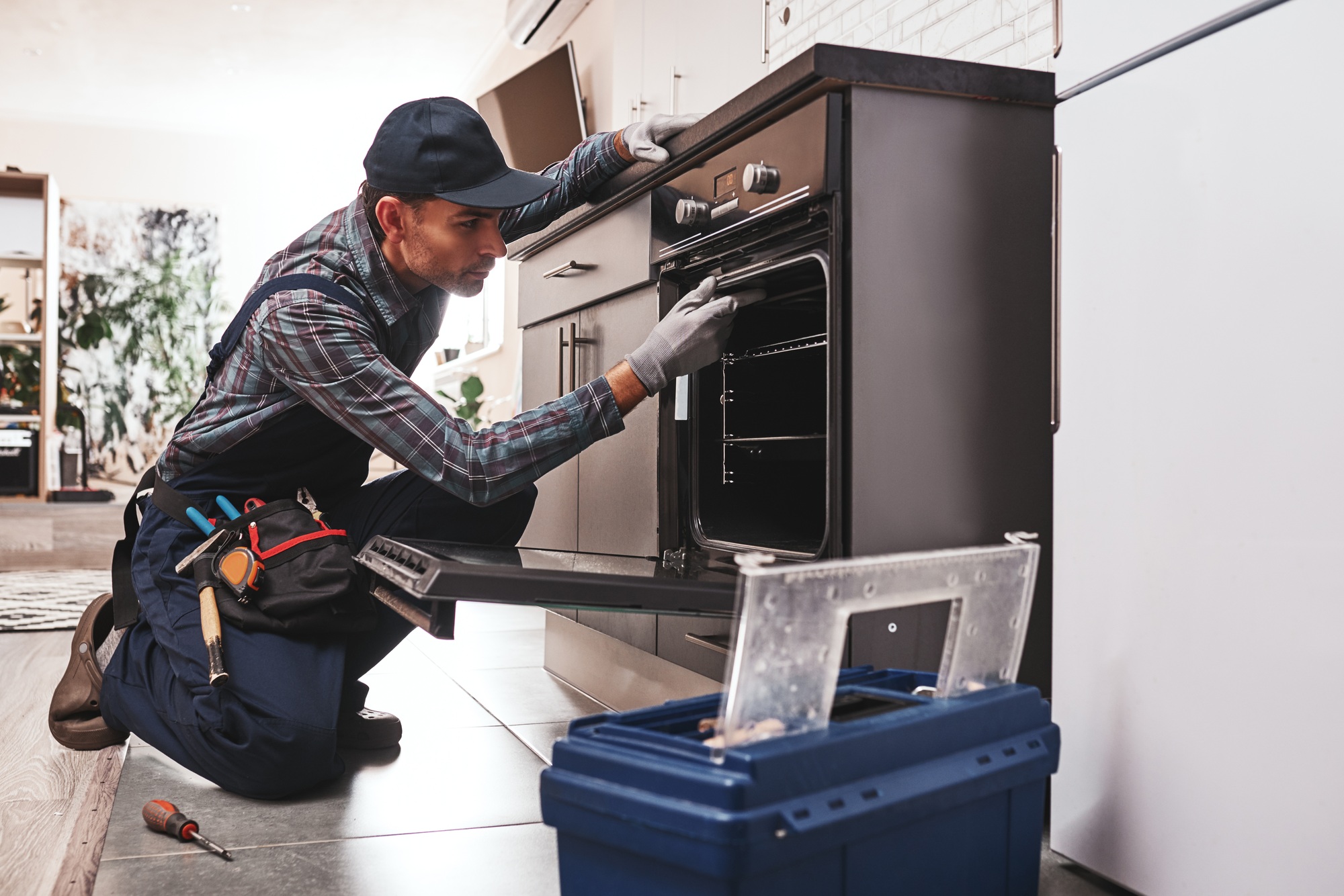 Don't delay with repair. Close-up of repairman examining oven