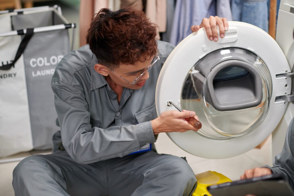 Repairman Fixing Washing Machine